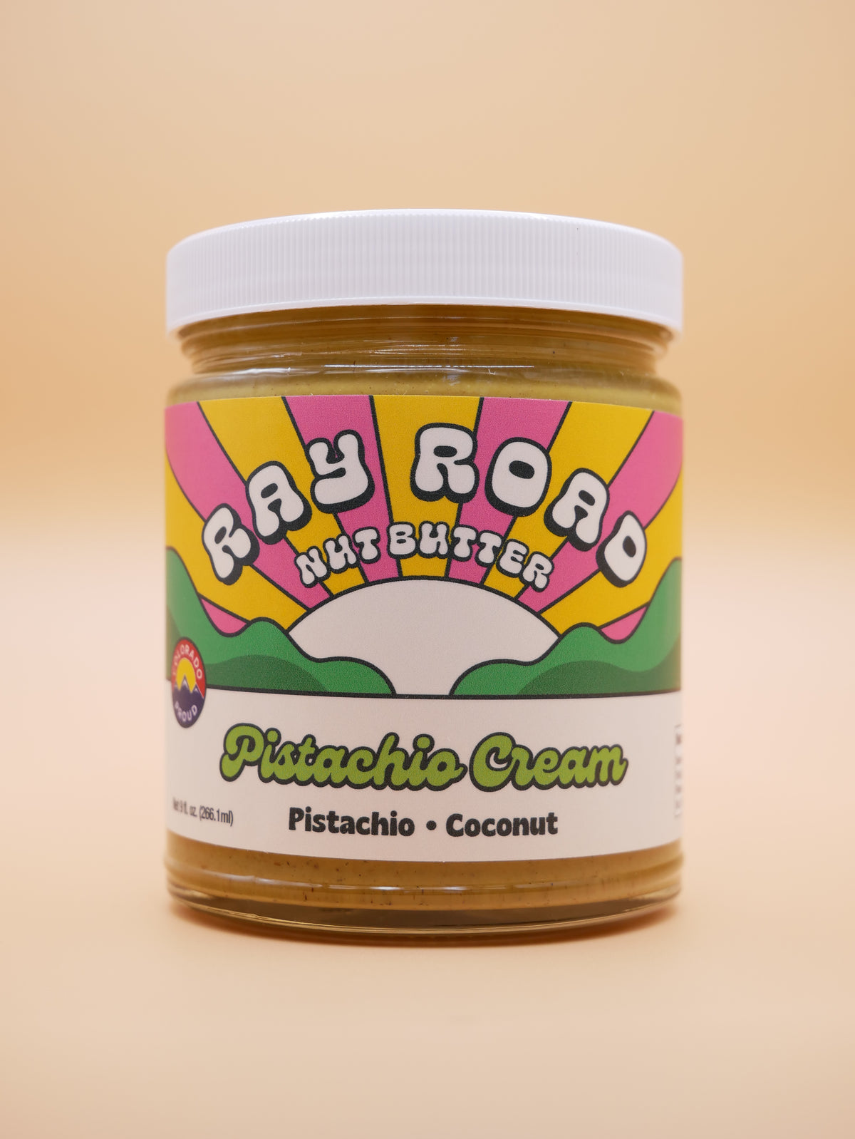 Jar of ray road nut butter pistachio cream with peach background