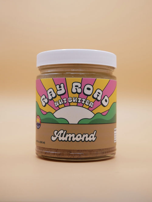 jar of ray road nut butter almond butter, brown label, rainbow logo, peach background