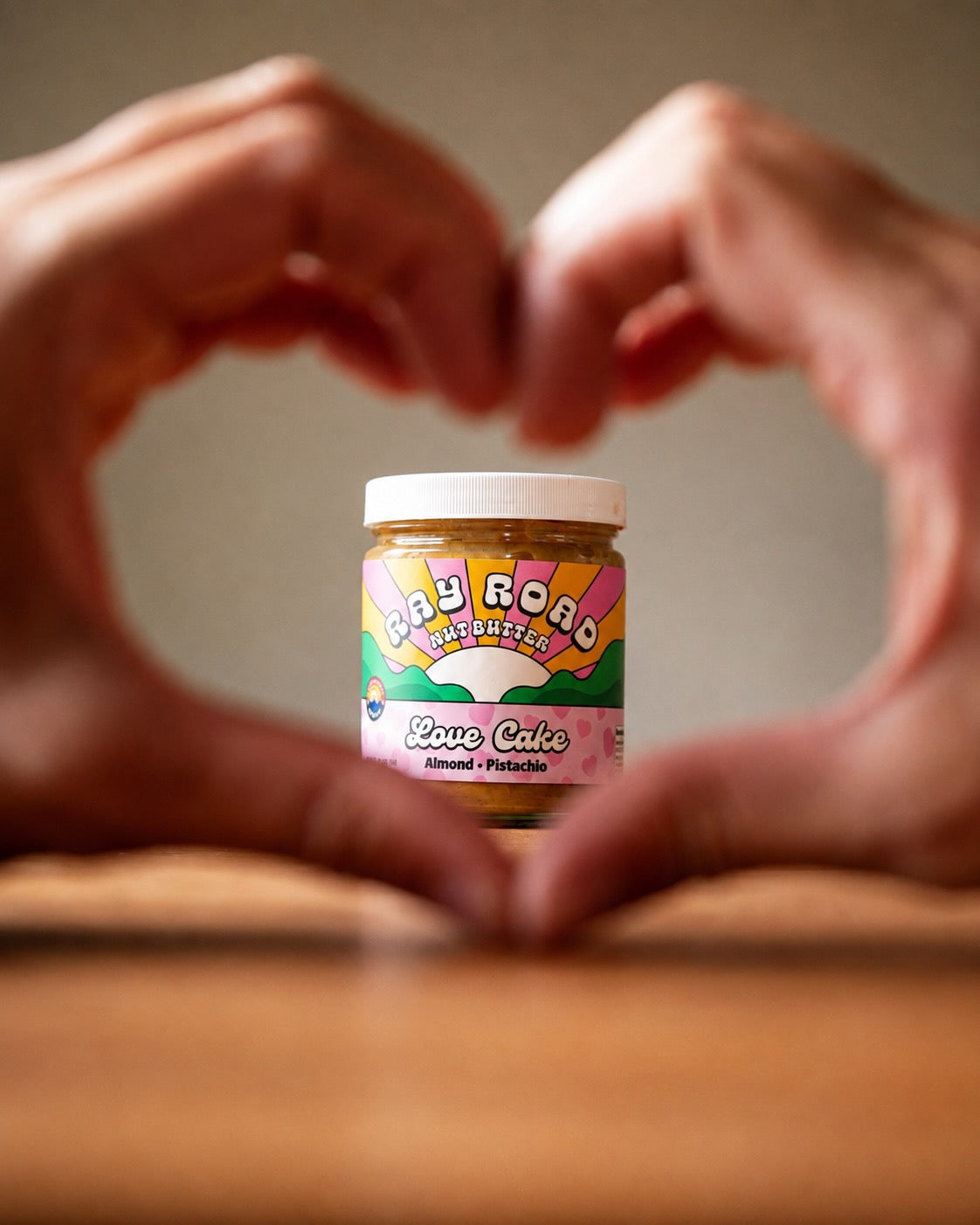 Love Cake jar framed by hands making a heart