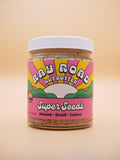 jar of super seeds Ray Road Nut Butter, pink label with a peach background
