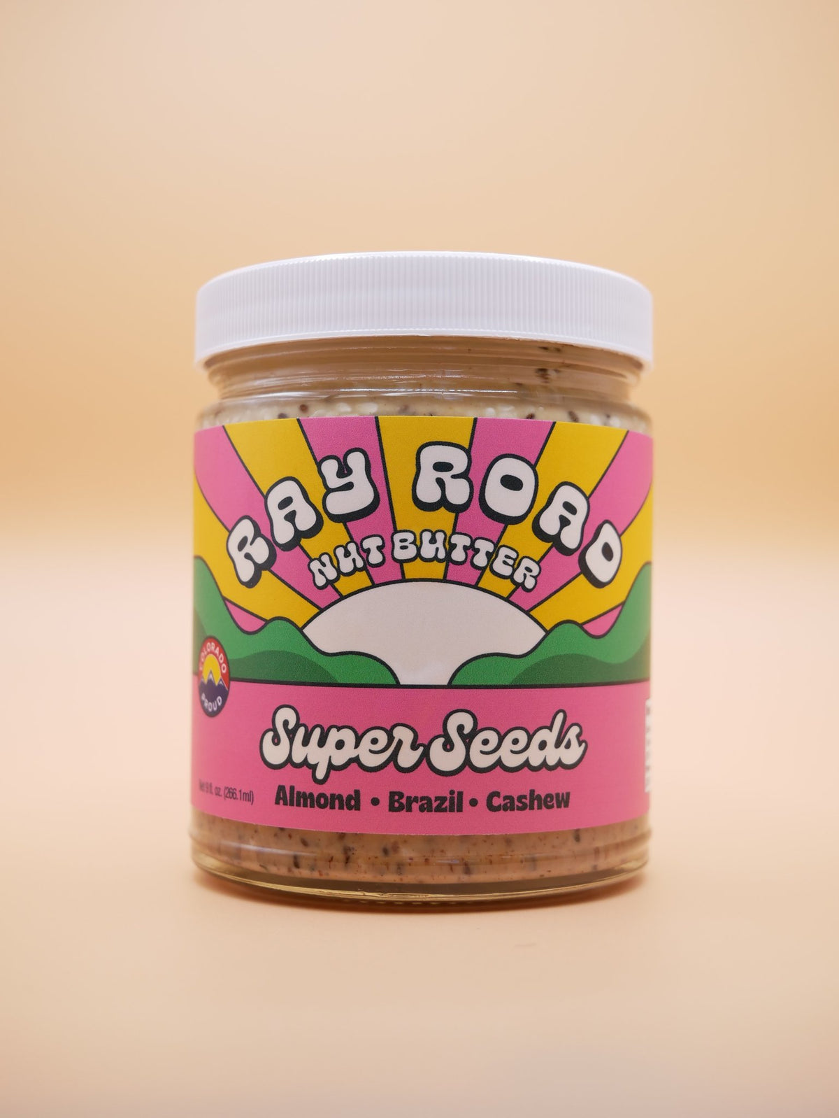 jar of super seeds Ray Road Nut Butter, pink label with a peach background