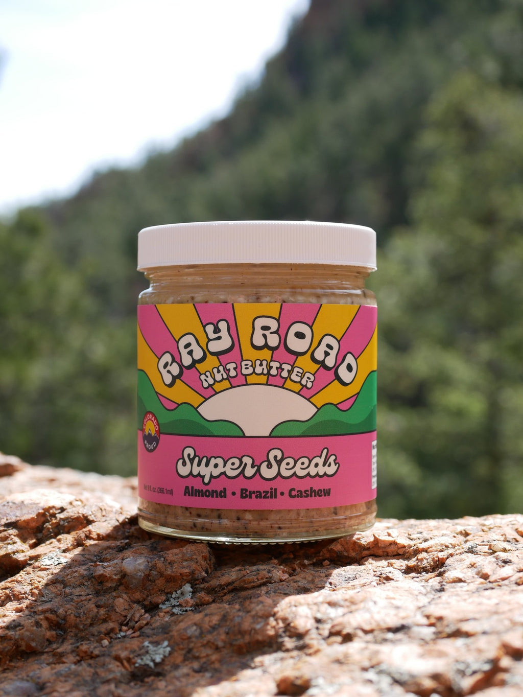 jar of super seeds on a rock with green tree back ground
