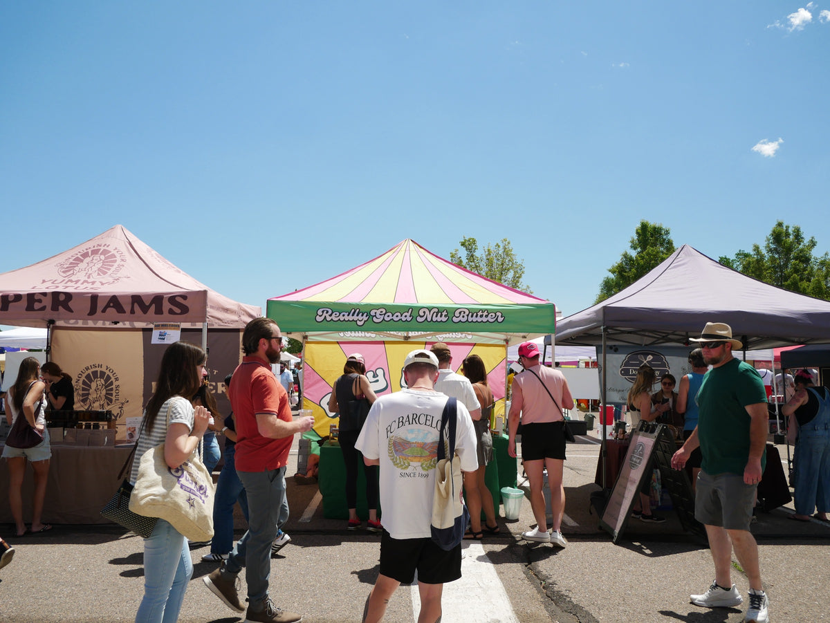 The Ray Road stall at an outdoor farmers market with shoppers browsing